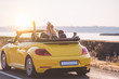 © Artem - The four friends travel in a yellow cabriolet