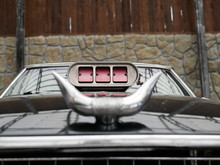 Carburetor Air Intake With Red Flaps. Bull Horns Made Of Silver-colored Metal On The Hood Of A Black Car. The Decoration Of The Car In The Texas Style.