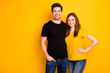 Poster - Photo of cheerful positive nice cute pretty couple hugging with man holding hand in jeans denim pocket smiling toothily isolated over vivid color background