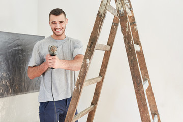 Wall Mural - Young man as a handyman with power drill