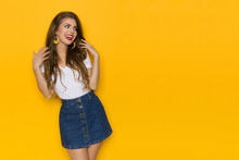 Happy Young Woman In Jeans Mini Skirt Is Looking Away And Talking