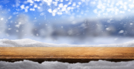 Wall Mural - A Christmas tabletop product display background with snow and blurred sunny blue sky bokeh.