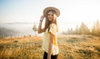 © Svetlana - Young carefree woman enjoying nature and sunlight in straw hat on top of hill