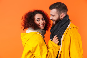 Sticker - Loving couple posing in yellow raincoats isolated