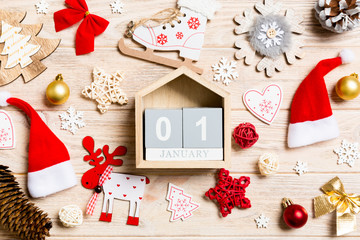 Top view of calendar on Christmas wooden background. The first of January. New Year toys and decorations. Holiday concept