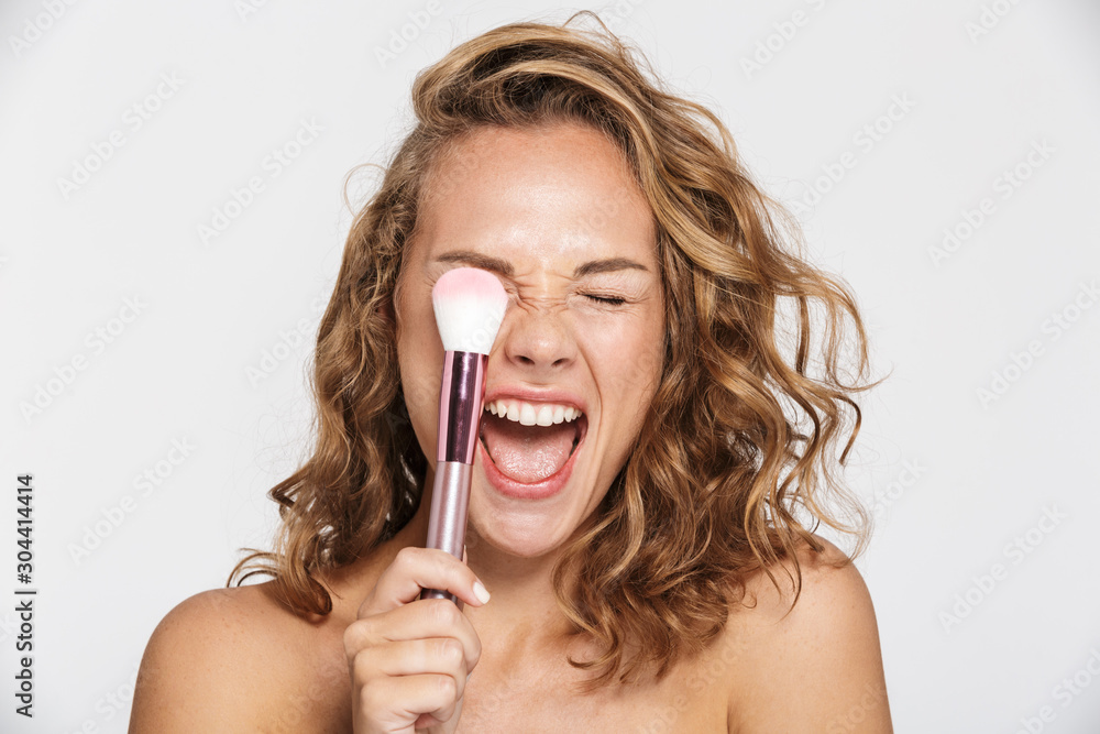 Image of half-naked woman making fun with makeup brush and screaming - obrazy, fototapety, plakaty 