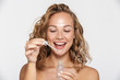 © Drobot Dean - Image of happy half-naked woman smiling and using facial serum