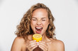 Image of displeased half-naked woman grimacing and eating lemon