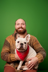 Happy man with beard with french bulldog in his arms