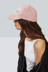 Wall Mural - Cropped side photo of a girl, wearing pink velvet baseball cap with embroidery lettering 