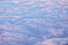 Beautiful Clouds Surface In Sunset Sky, View From Plane During Flight. Pink And Blue Cloudscape Look Like A Snow.