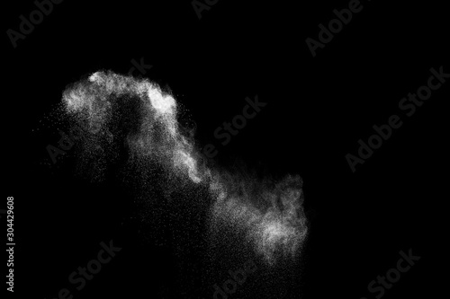 White powder explosion cloud against black background.White dust particles sp...