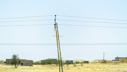 Wall Mural - installation of a new electricity supply poles without it's cables in the middle of desert in Saudi Arabia  