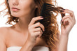 cropped view of girl brushing curly hair isolated on white