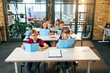 © gorynvd - Group of six young happy pupils sit at their desk and reading educational books in the lesson.