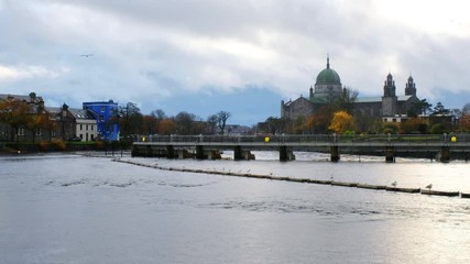 Wall Mural - Galway, Ireland. View of roman catholic cathedral of Galway, Ireland during the rainy day in autumn. River and cloudy sky