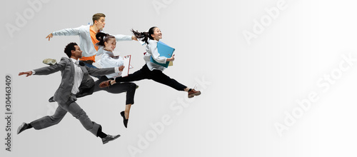 Happy office workers jumping and dancing in casual clothes or suit with folders on white Tableau sur Toile