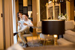 © BGStock72 - Young couple relaxing at home using digital tablet in the living room by the window