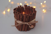 Closeup Of DIY Cinnamon Candle Holder With Burning Candle On White Background. Concept Of Christmas DIY And Zero Waste, Sustainable Decoration.