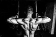© Srdjan - Young muscular fit sweaty strong man doing cross workout training for back muscles in the gym dark image real people black and white