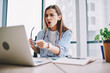 © BullRun - Emotional woman stressed while watching video on laptop computer sitting in office interior, shocked female pointing on netbook irritated about application failure during working process at desktop.