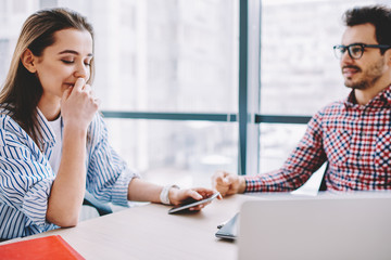 Wall Mural - contemplative female employee listening to male colleague explaining ideas during cooperation in off