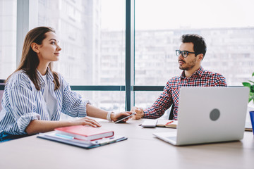 Wall Mural - serious female and male colleagues discussing ideas for business startup sitting at desktop together