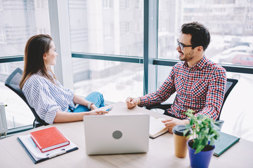 Wall Mural - positive male and female colleagues communicating and cooperating in office, smiling employees talki