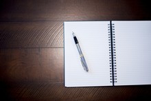 Overhead Shot Of A Fountain Pen On An Open Notebook On A Wooden Surface