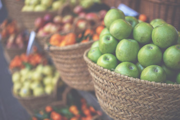 Wall Mural - Market stall with variety of organic vegetable. Fresh organic produce on sale at the local farmers market. Ripe organic apples in a basket.