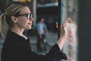 Wall Mural - smiling female standing at big display with advanced digital technology. young woman touching with f