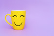 © Veronika - Smiley yellow coffee cup on purple background. Happy friday word concept. Minimalism style, romantic mood, good morning, happiness, break time