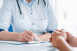 © InsideCreativeHouse - Close up of doctor and patient sitting at the desk in clinic
