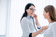 © InsideCreativeHouse - Female doctor listening to patients chest with stethoscope at the hospital