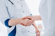 © InsideCreativeHouse - Close up of woman doctor shaking hands with patient