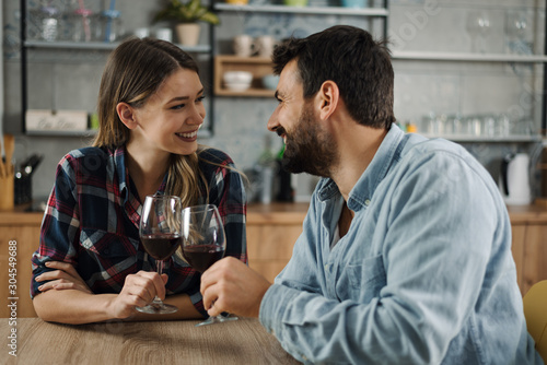 Cuadros en Lienzo Young couple in love enjoying in conversation while drinking red wine