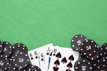 Wall Mural - Royal Flush cards and poker chips on green flat lay background.