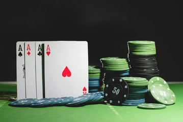 Wall Mural - Four aces cards and poker chips on the green table background.