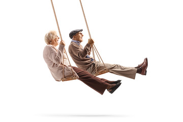 Sticker - Elderly man and woman swinging on a wooden swings