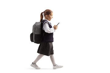 Wall Mural - Schoolgirl walking and looking surprised with a mobile phone