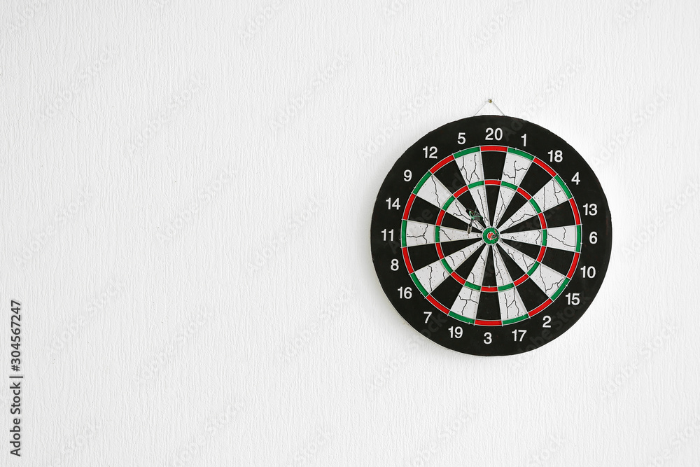 Dartboard hanging on light wall