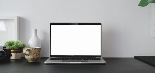 Canvas Print - cropped shot of open blank screen laptop computer with office supplies and copy space in modern offi