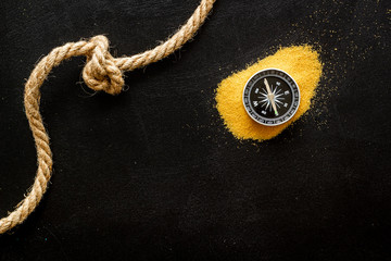 Wall Mural - Goal achievement concept. Compass near rope with knot on black background top view copy space