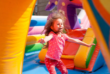 A Cheerful Child Plays In An Inflatable Castle