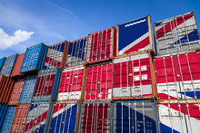 The National Flag Of United Kingdom On A Large Number Of Metal Containers For Storing Goods Stacked In Rows On Top Of Each Other. Conception Of Storage Of Goods By Importers, Exporters