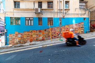 A motorcycle courier passing by the famous Graham Street Wall Mural, a colorful street art and a popular Instagram check-in spot in Central District, Hong Kong, China, Asia