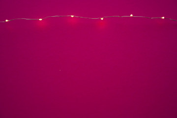 Wall Mural - Illuminated garland lights on bright pink background