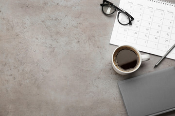 Canvas Print - Flat lay composition with calendar and cup of coffee on grey stone table. Space for text