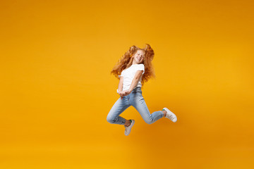 Wall Mural - Pretty little ginger kid girl 12-13 years old in white t-shirt isolated on yellow background children portrait. Childhood lifestyle concept. Mock up copy space. Having fun, fooling around, jumping.