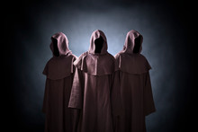 Group Of Three Scary Figures In Hooded Cloaks
